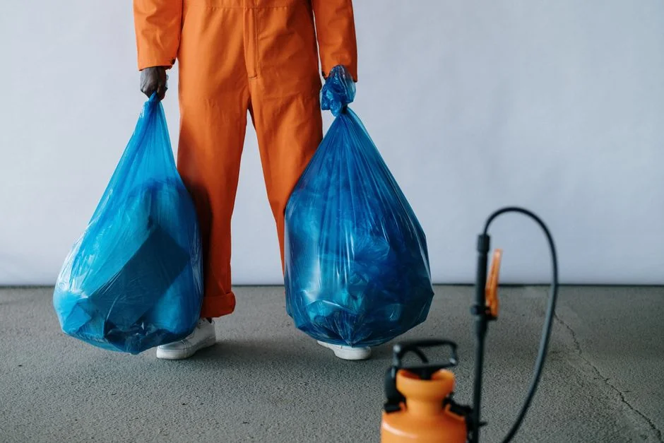 services-02 An individual disinfects a workspace using fumigation, wearing full protective gear for safety.